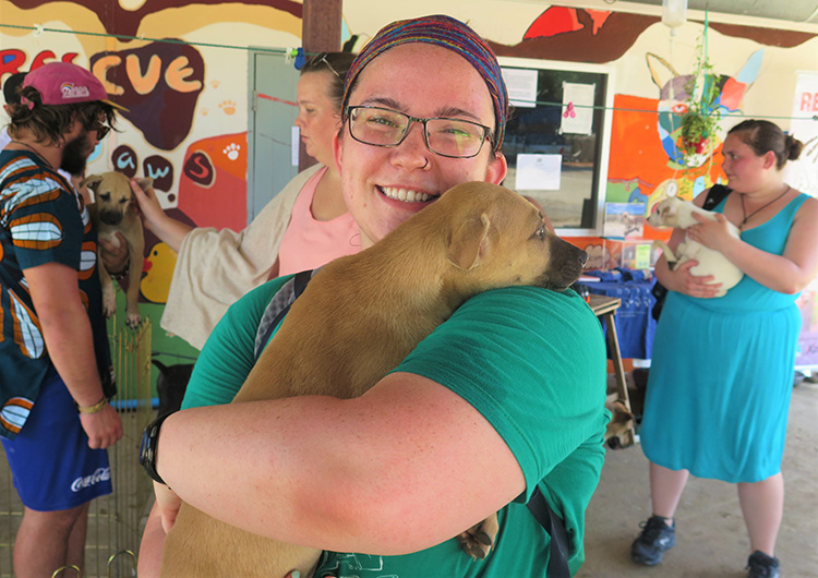 A Greenheart Travel volunteer holds a puppy in Thailand. 