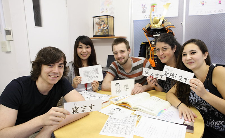 A group of students hold up Japanese writing.