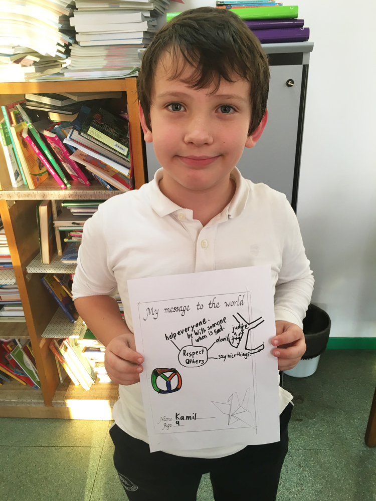 A boy shows his artwork.