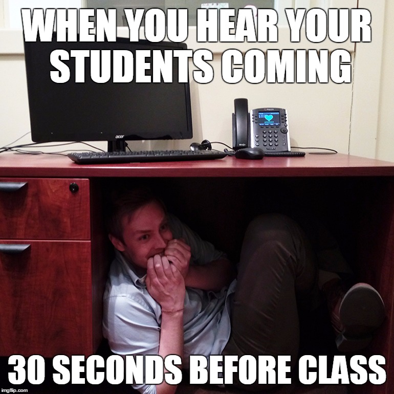 A teacher hiding under a desk.