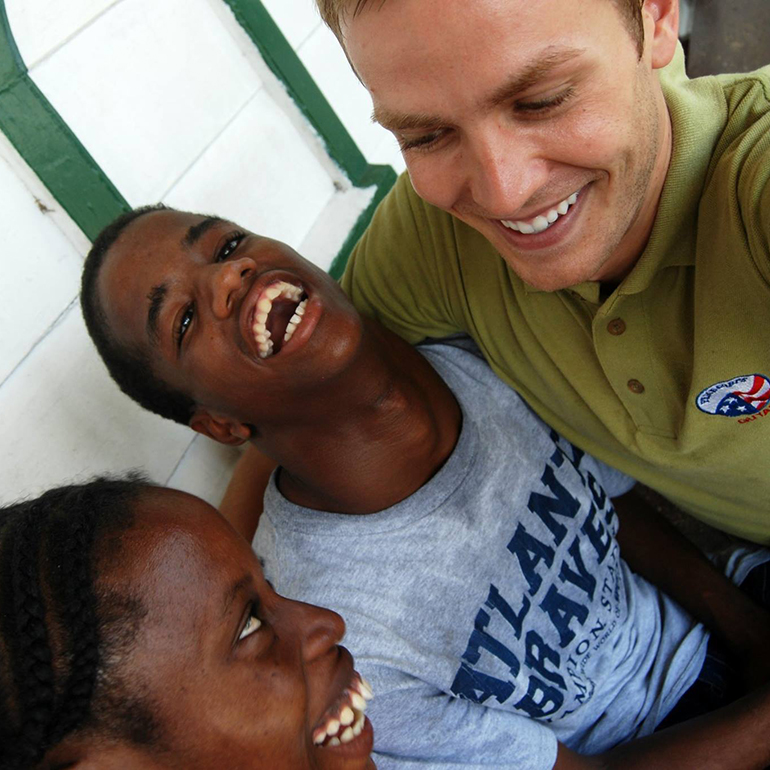 Two students and a teacher take a selfie in Guyana.