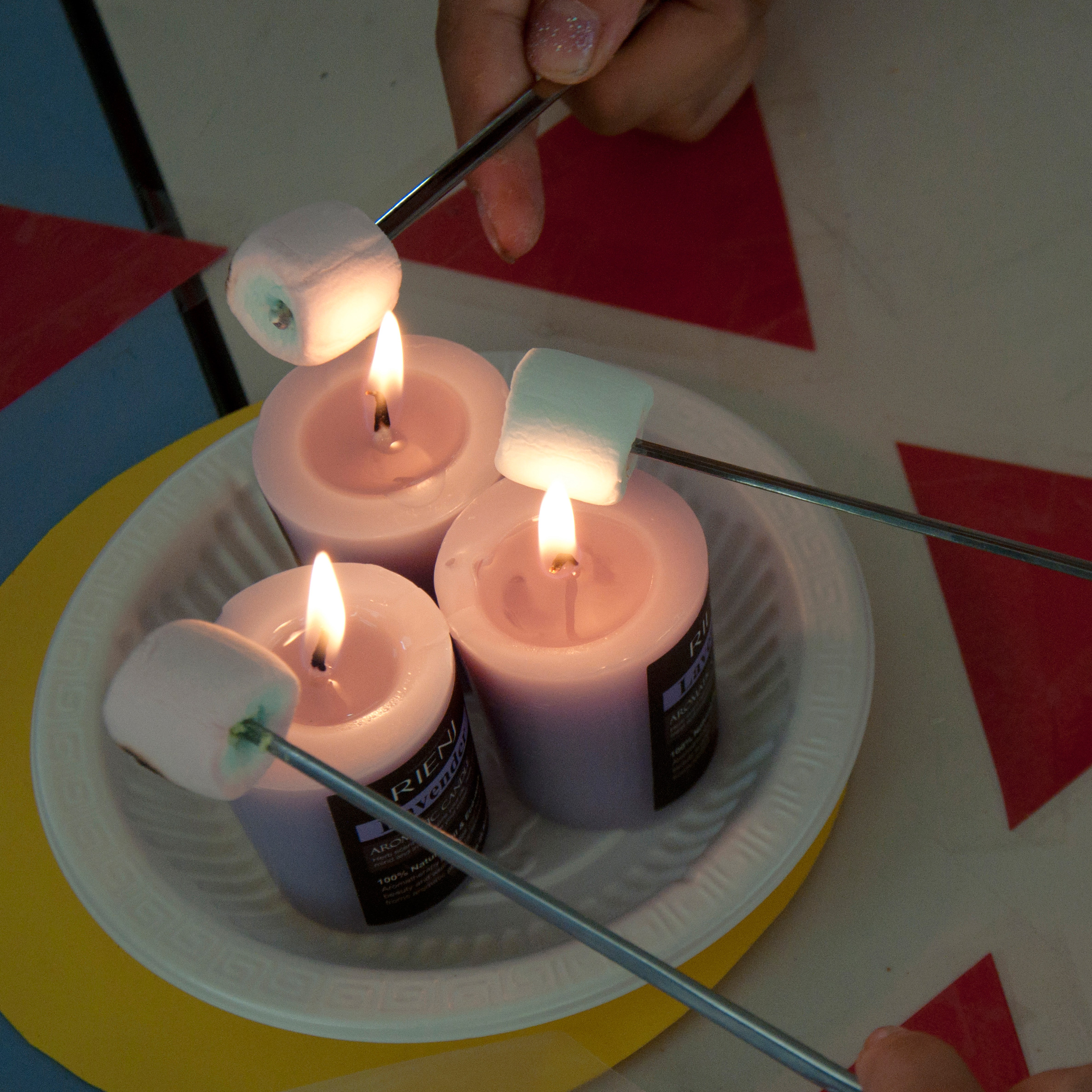 Roasting marshmallows over small candles.