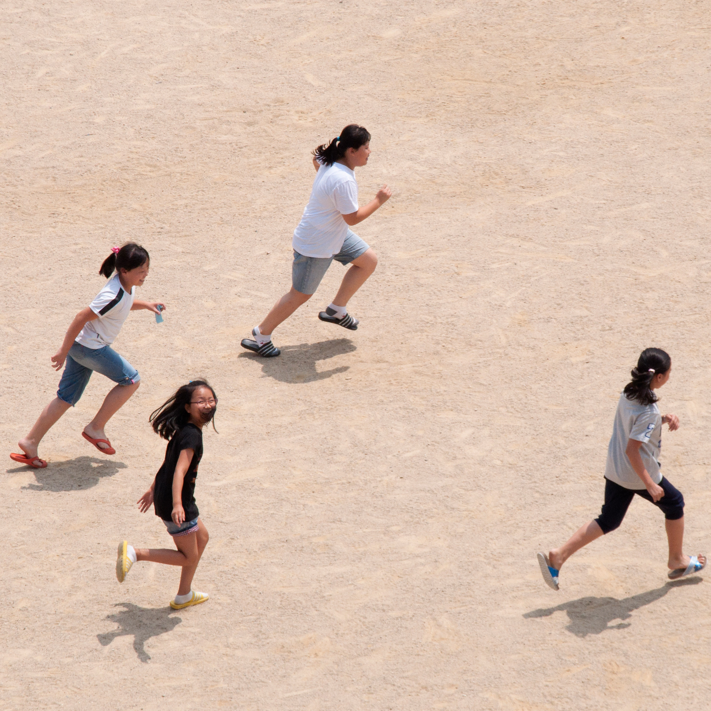 A group of students running in a schoolyard.