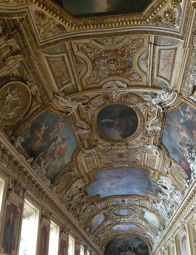 The ornate ceiling inside the Louvre in Paris, France.