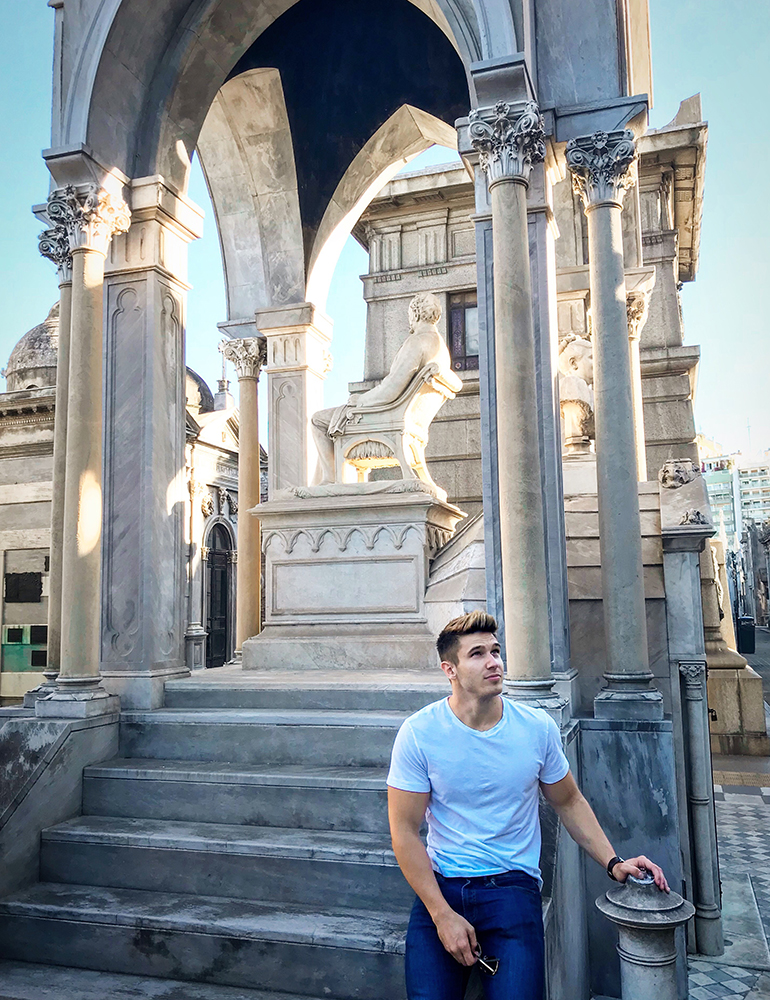Greenheart Traveler, Sam Cushing, posing in front of architecture in Argentina.