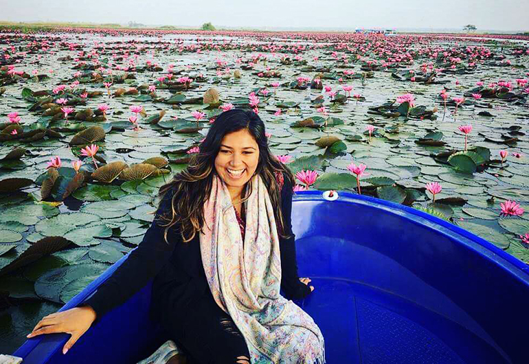 Greenheart Traveler, Varshini Kumar, in a boat surrounded by lotuses. 