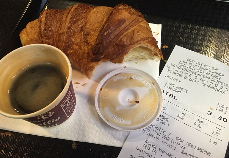 A croissant, espresso, and receipt in a French cafe.