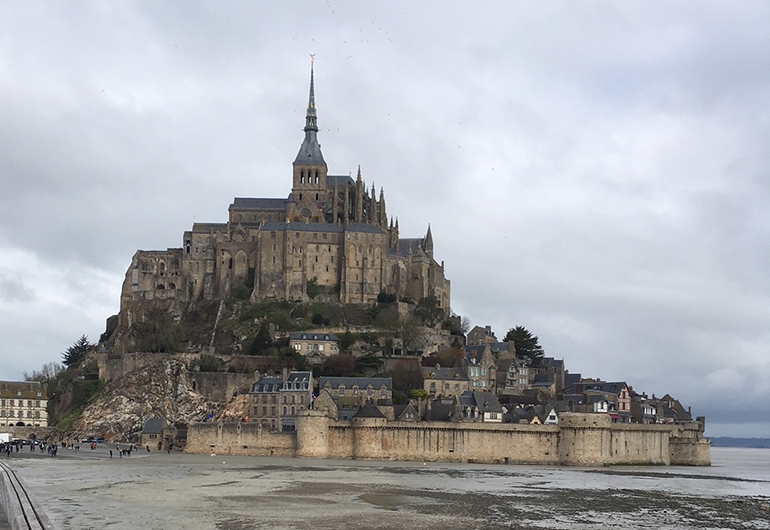 Le Mont Saint-Michel next in Normandy, France on a cloudy day.