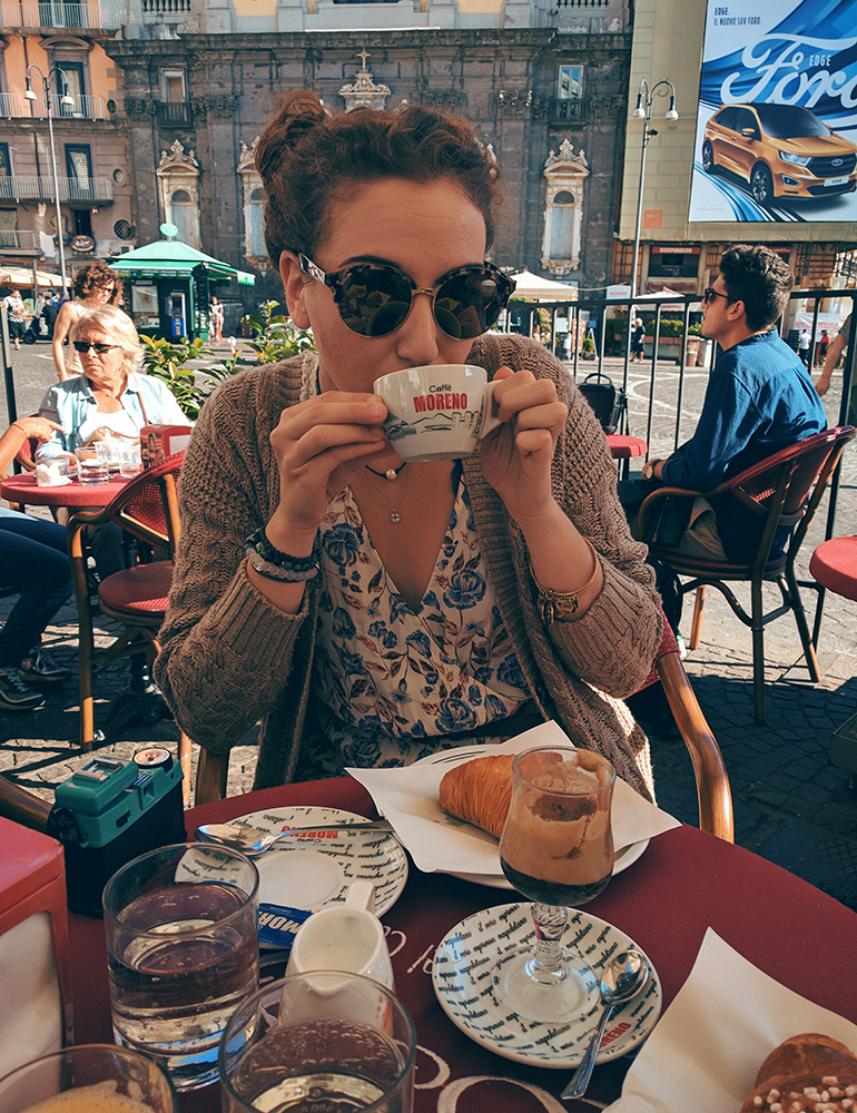 Mikaela drinking espresso and having a cornetto at a cafe in Naples, Italy.