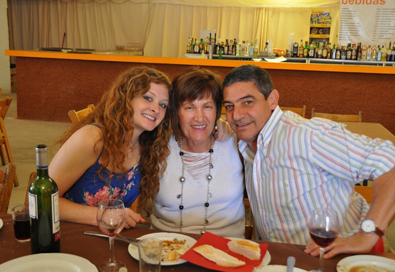 A student has dinner with her homestay parents in Spain.
