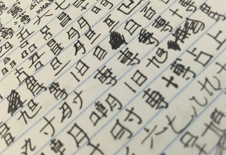 Emily's notebook with Japanese kanji writing.