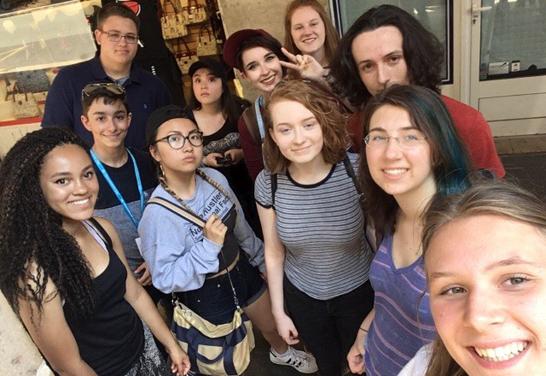 Noam and her friends takng a big group selfie in France.