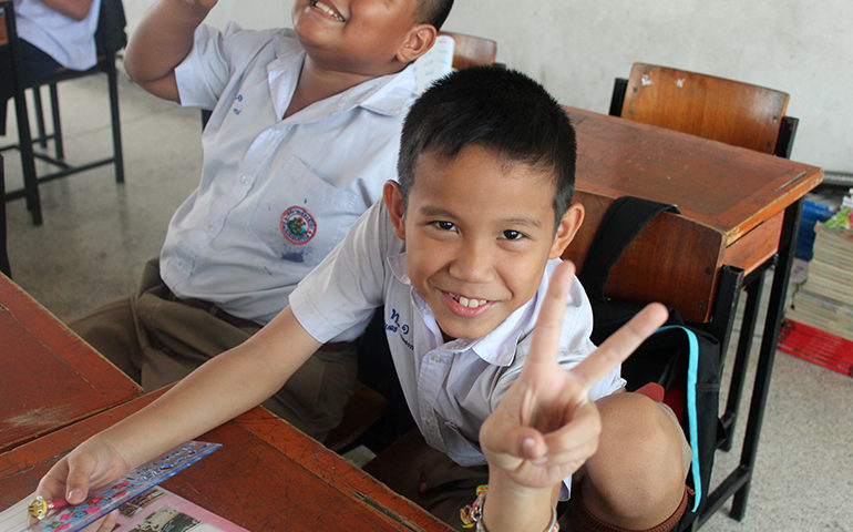 A child makes a peace sign with his hand.
