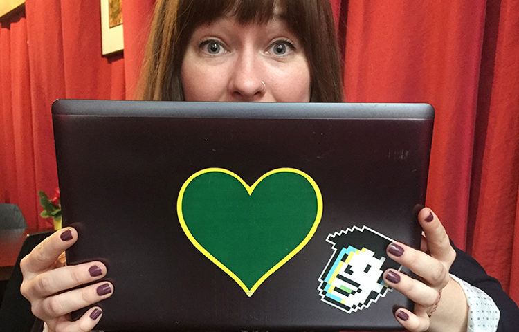A laptop with a Greenheart Travel sticker on it.
