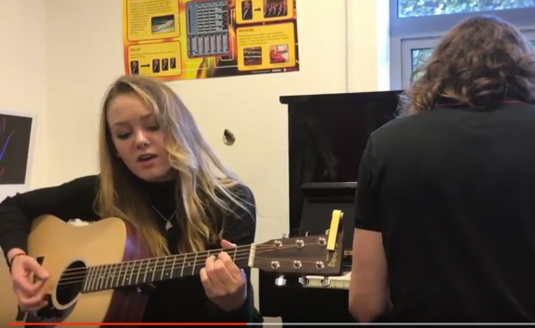 High school students playing guitar at school in the UK.