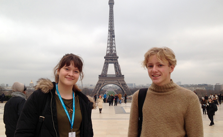 Greenheart Traveler, Ian Taraszewski, with a friend in front of the Eiffel Tower in Paris, France.