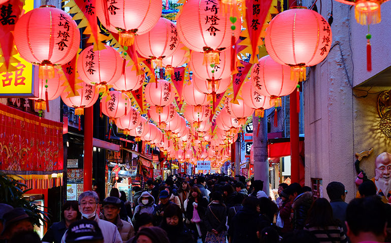 A latern festival lining the street in Japan at night.