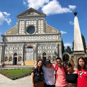 a group of students stand in front of a church in italy